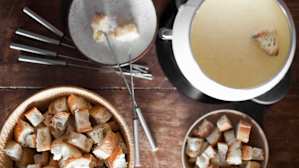 freshness, medium group of objects, no people, vertical, colour image, photography, point of view, high angle view, technique, camera focus, selective focus, foods and drinks, food, food staple, bread, meal, french food, fondue, equipment, utensil, cooking utensil, pot, tableware, bowl, cutlery, fork, indoors, food and drink, healthy eating, organic, simple living, the good life, cheese fondue, melted cheese, pot, long fork, fondue fork, view from above, buffet, special occasion