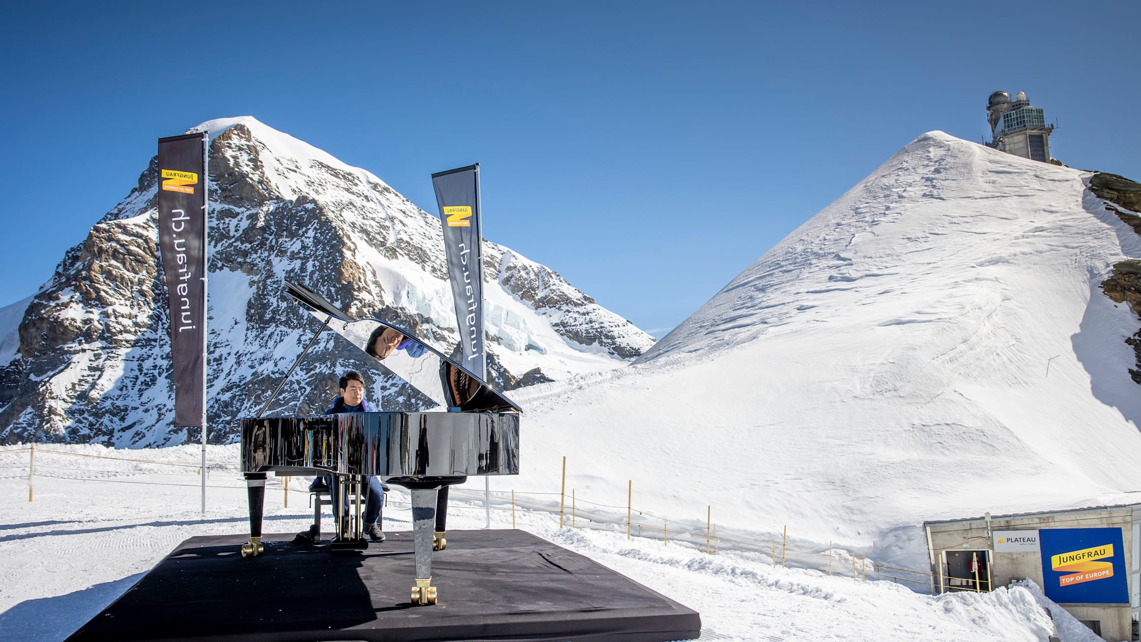 Lang Lang waehrend seines Konzertes auf dem Jungfraujoch Top of Europe mit dem Moench und der Sphinx im Hintergrund
