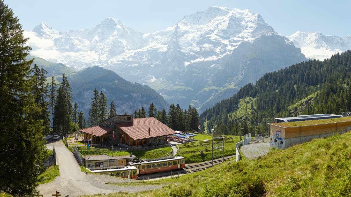 https://media.jungfrau.ch/image/upload/f_auto,fl_lossy,q_auto,c_crop,ar_16:9/c_scale,w_1357/v1479841709/fileadmin/Winteregg_Muerren/Winteregg-Muerren-Restaurant-Sommer-Panorama-Eiger-Moench-Jungfrau.jpg
